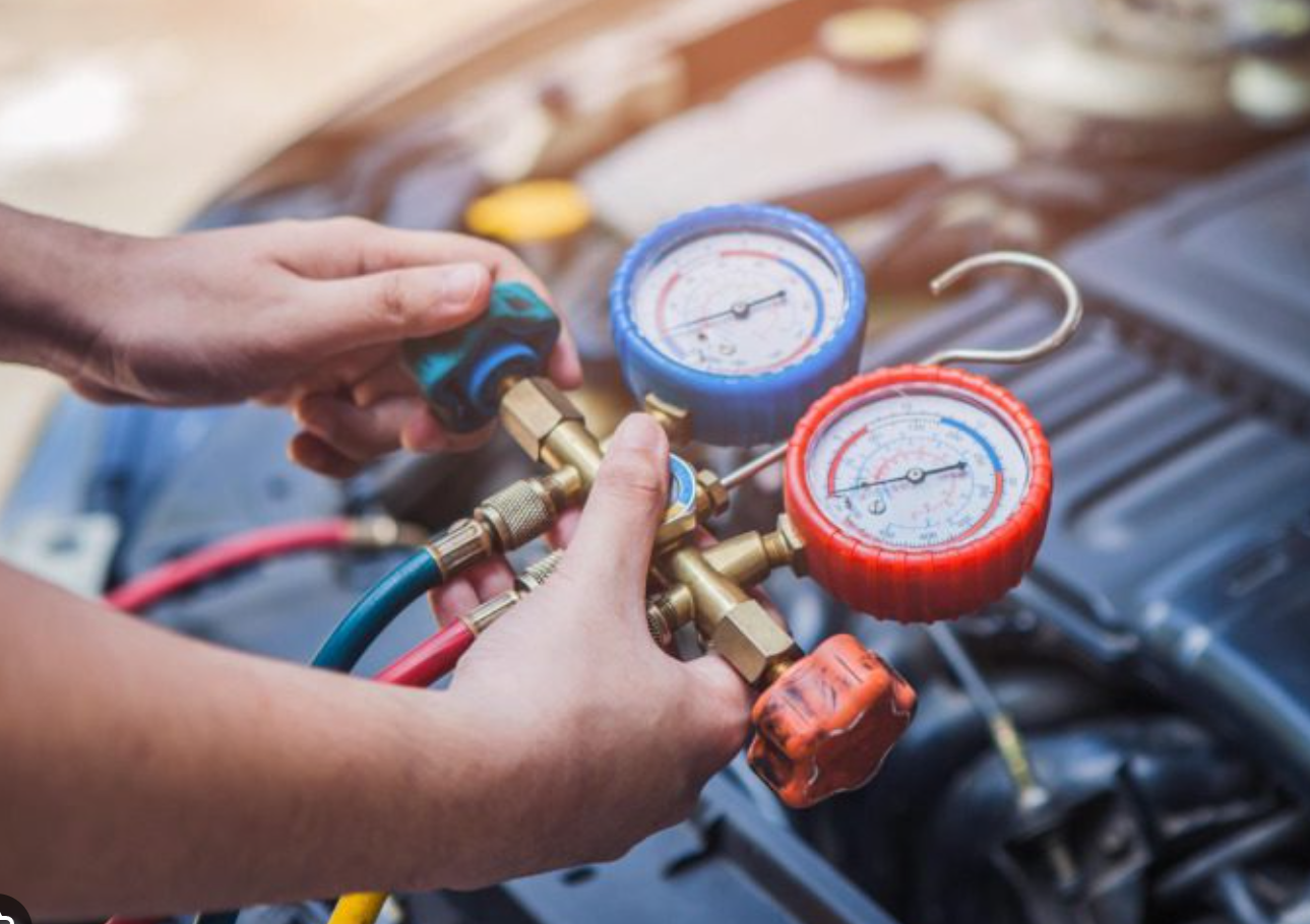 Mechanic testing A/C system with gauges